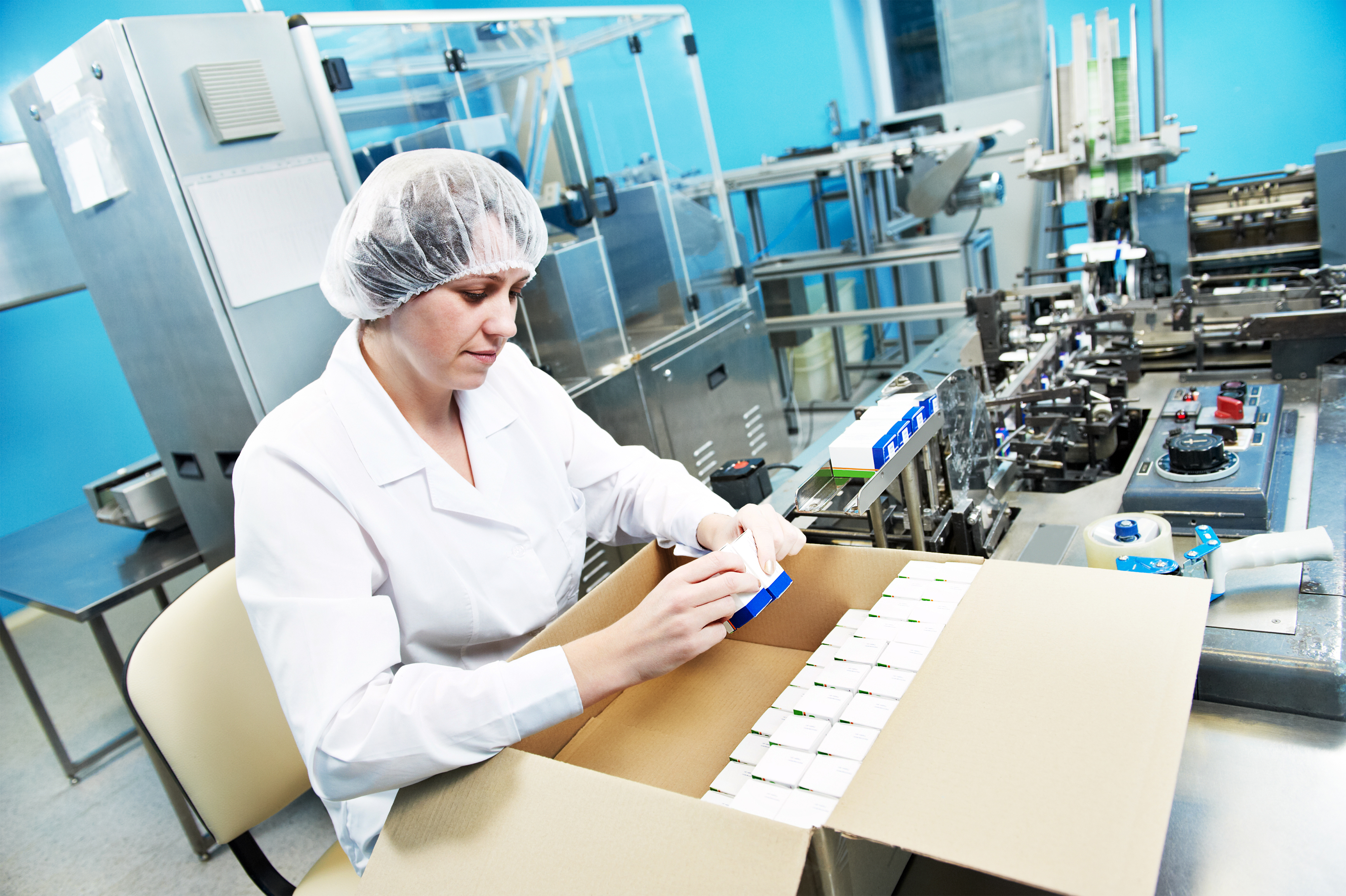 pharmaceutical factory worker at pharmacy industry manufacture packing medicine into boxes