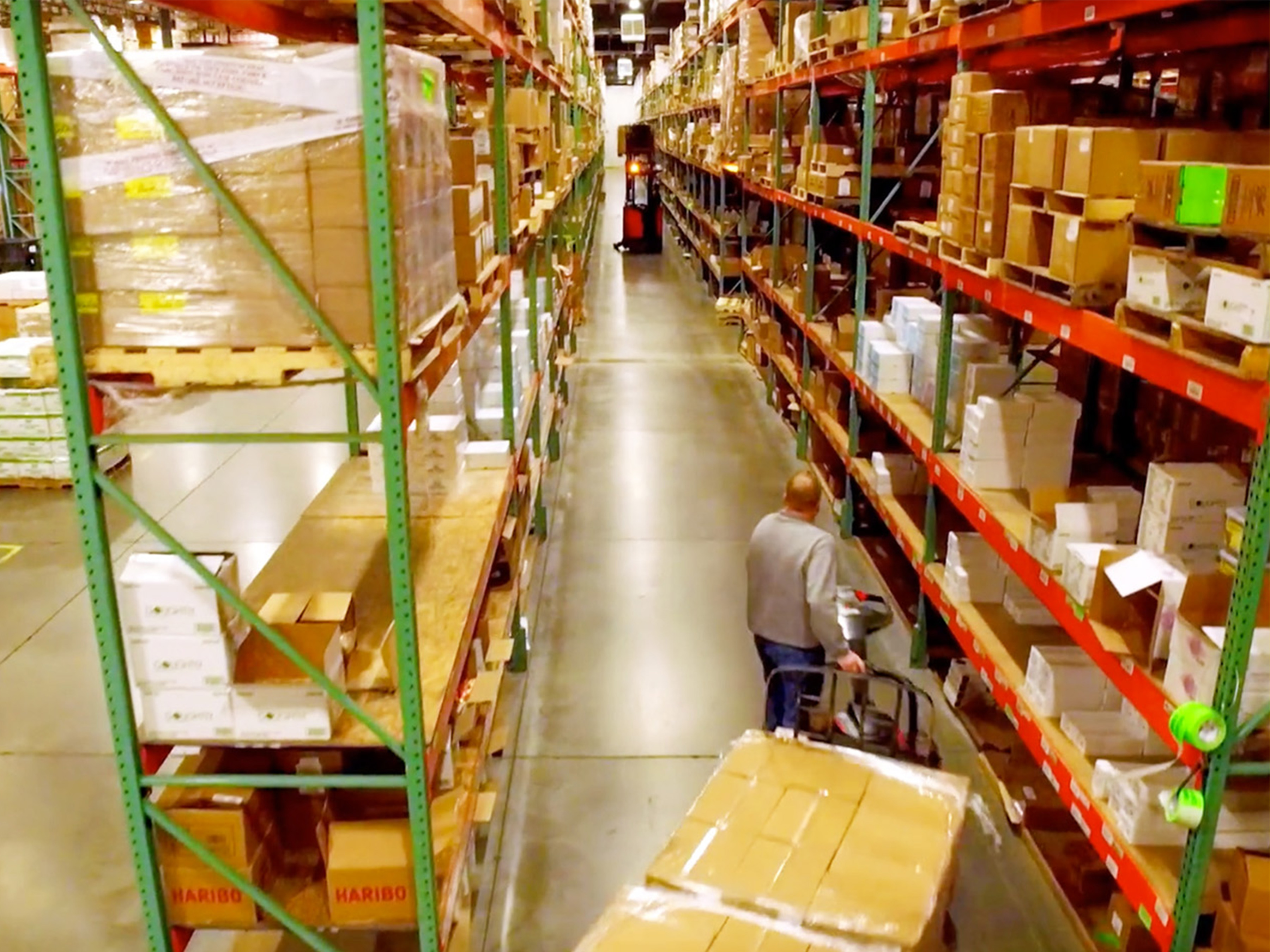 Man pulling cart of boxes on a warehouse