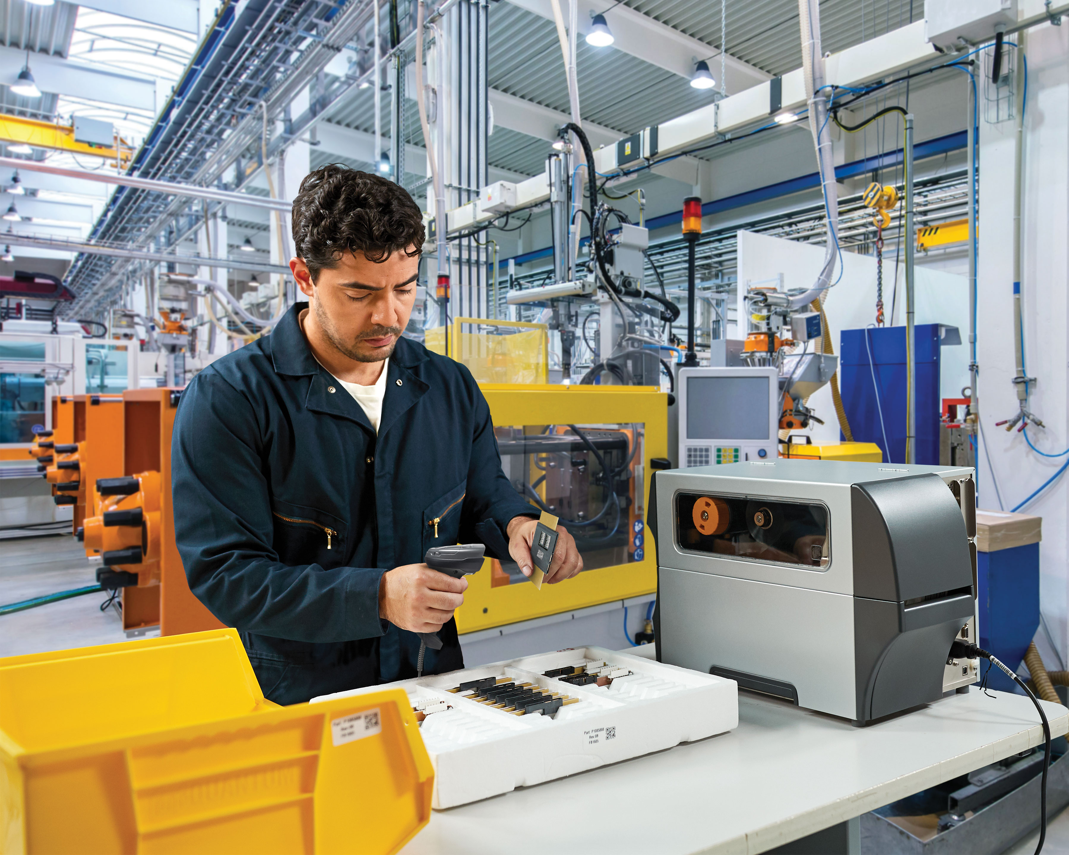 Manufacturing worker uses the Zebra DS4600 handheld scanner to scan QR code of electronics