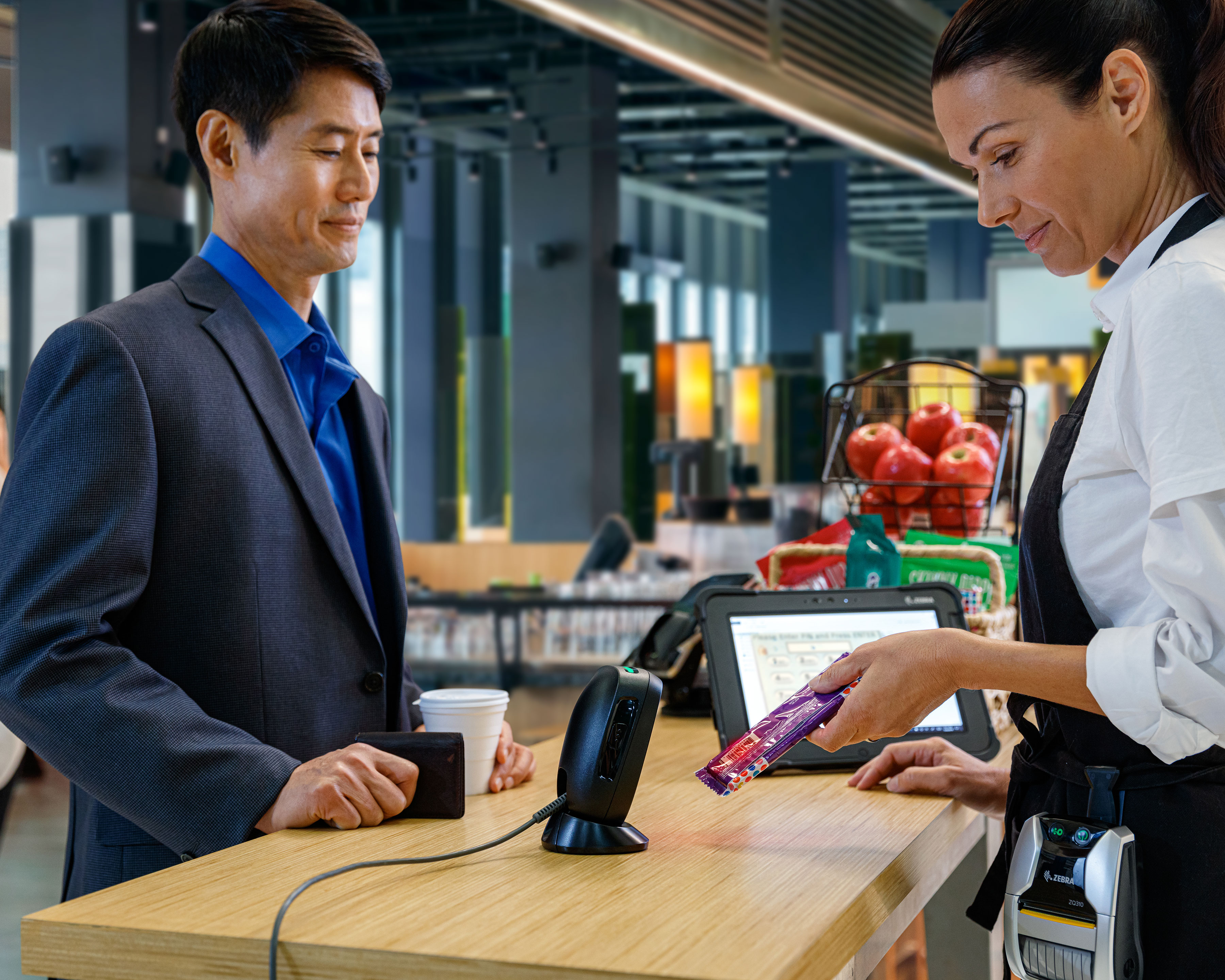 Convenience store worker uses Zebra DS9300 hands free barcode scanner to scan a chocolate bar barcode at the checkout counter