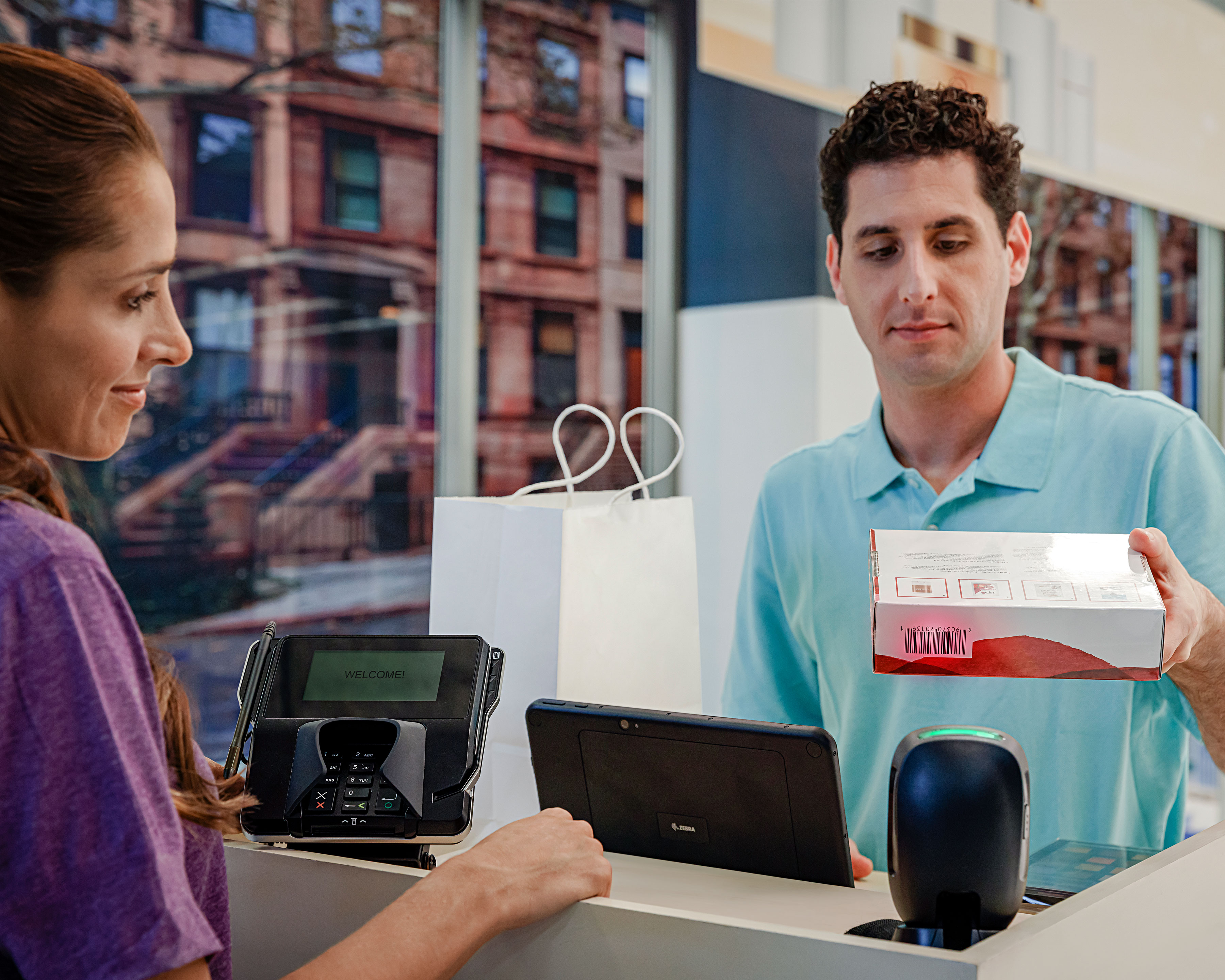 Drugstore clerk uses Zebra DS9300 hands free barcode scanner to scan product box at the checkout counter