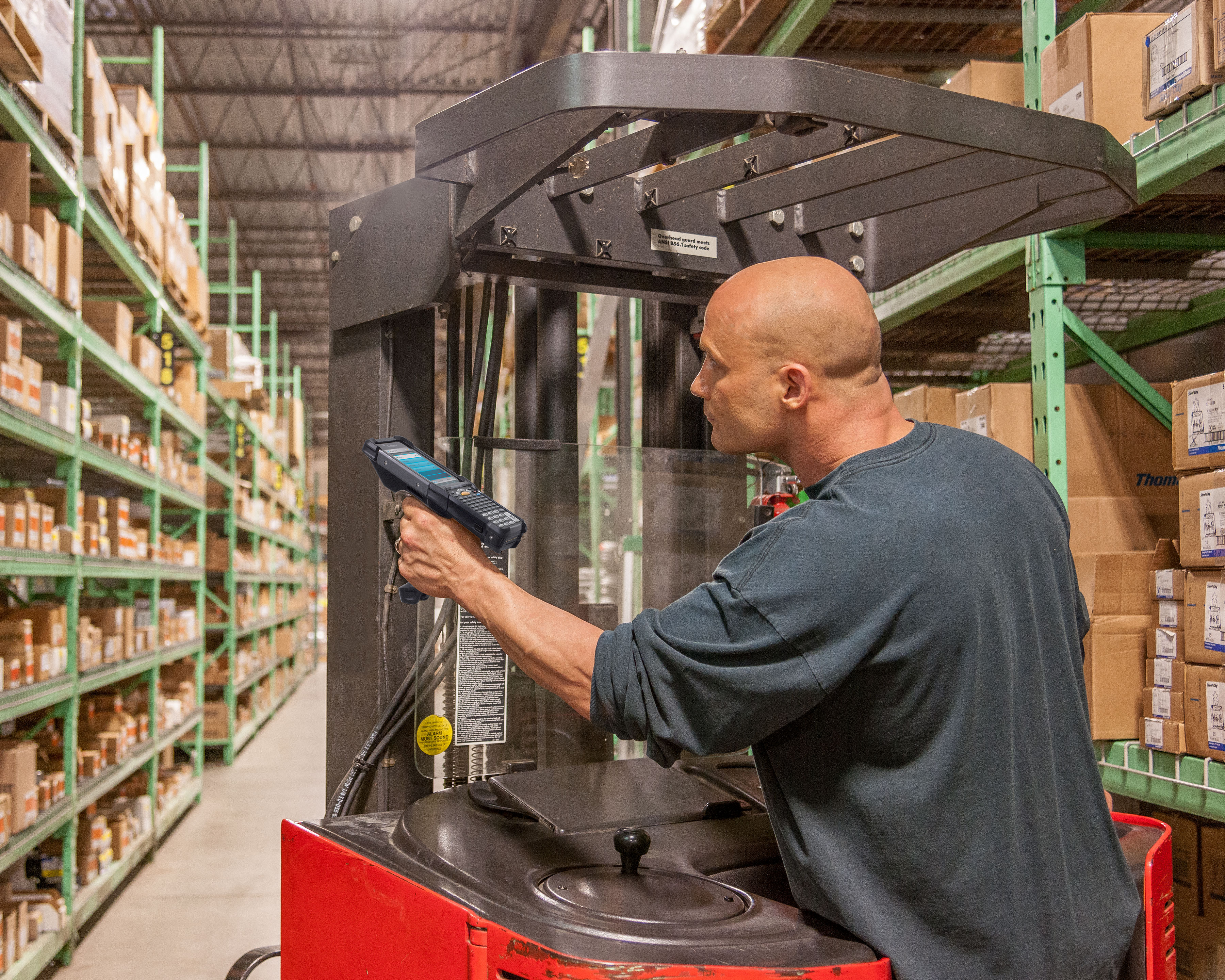 Warehouse worker on a forklift uses Zebra MC9300 mobile computer for long range scanning