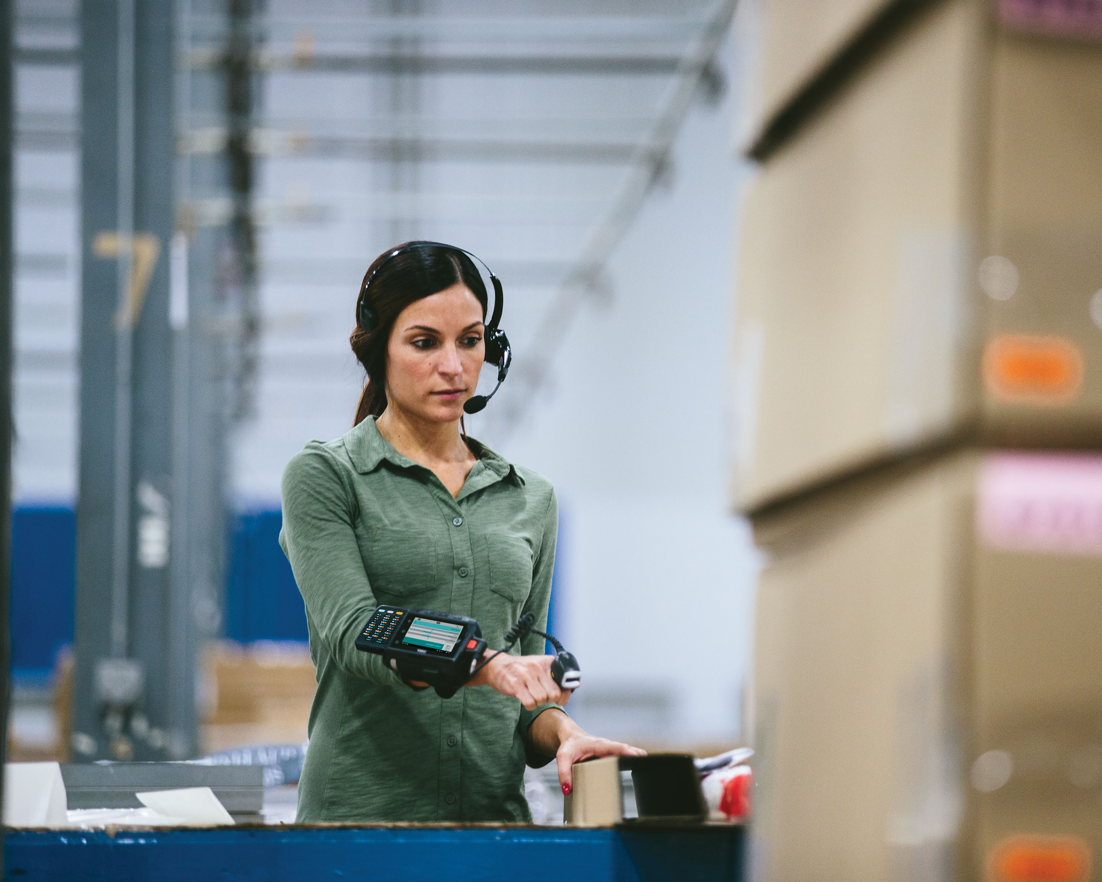 Worker scanning boxes with Zebra RS4000 ring scanner for warehouse sorting