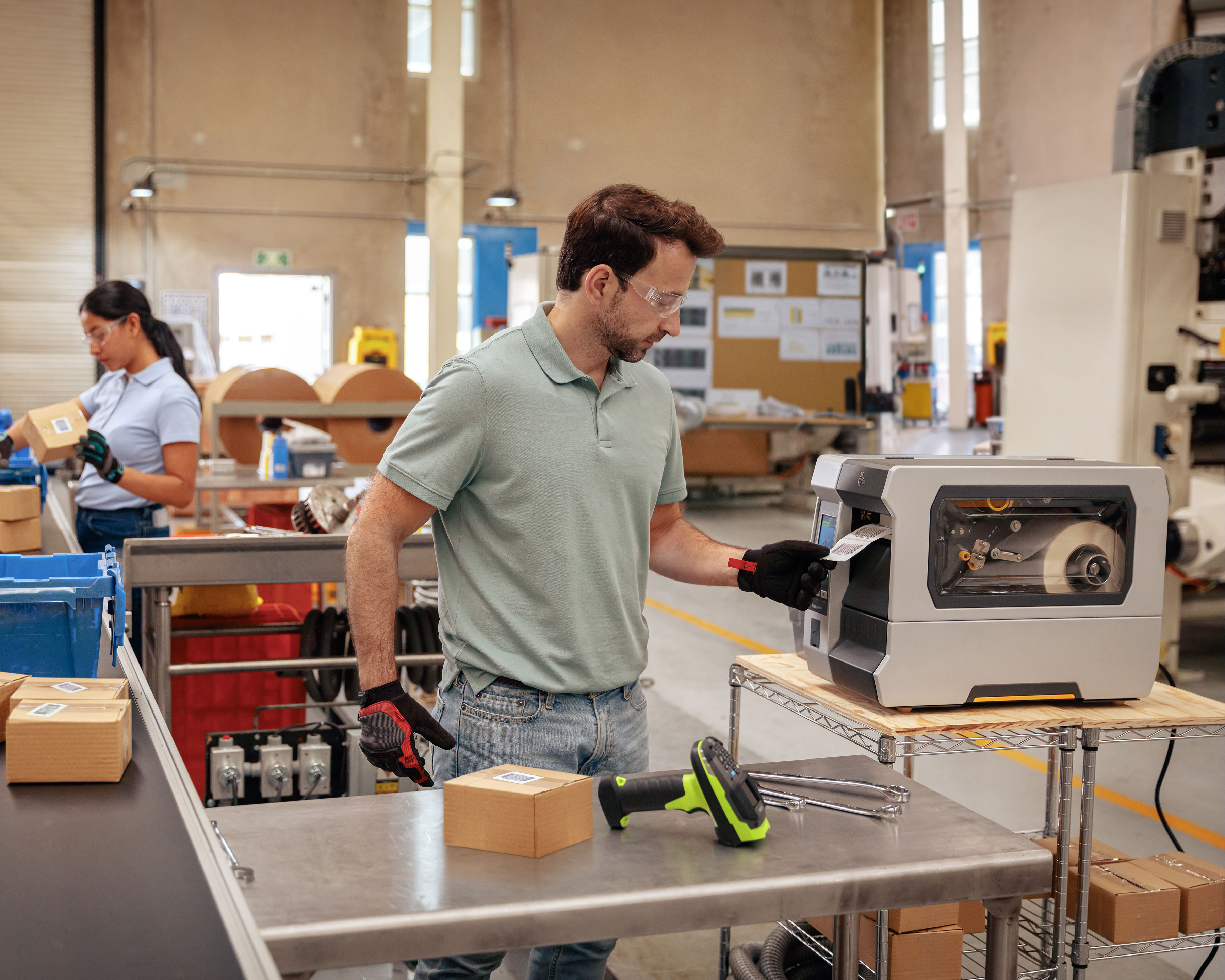 Manufacturing worker uses Zebra ZT600 industrial printer to print out barcode labels at the packing and sorting center