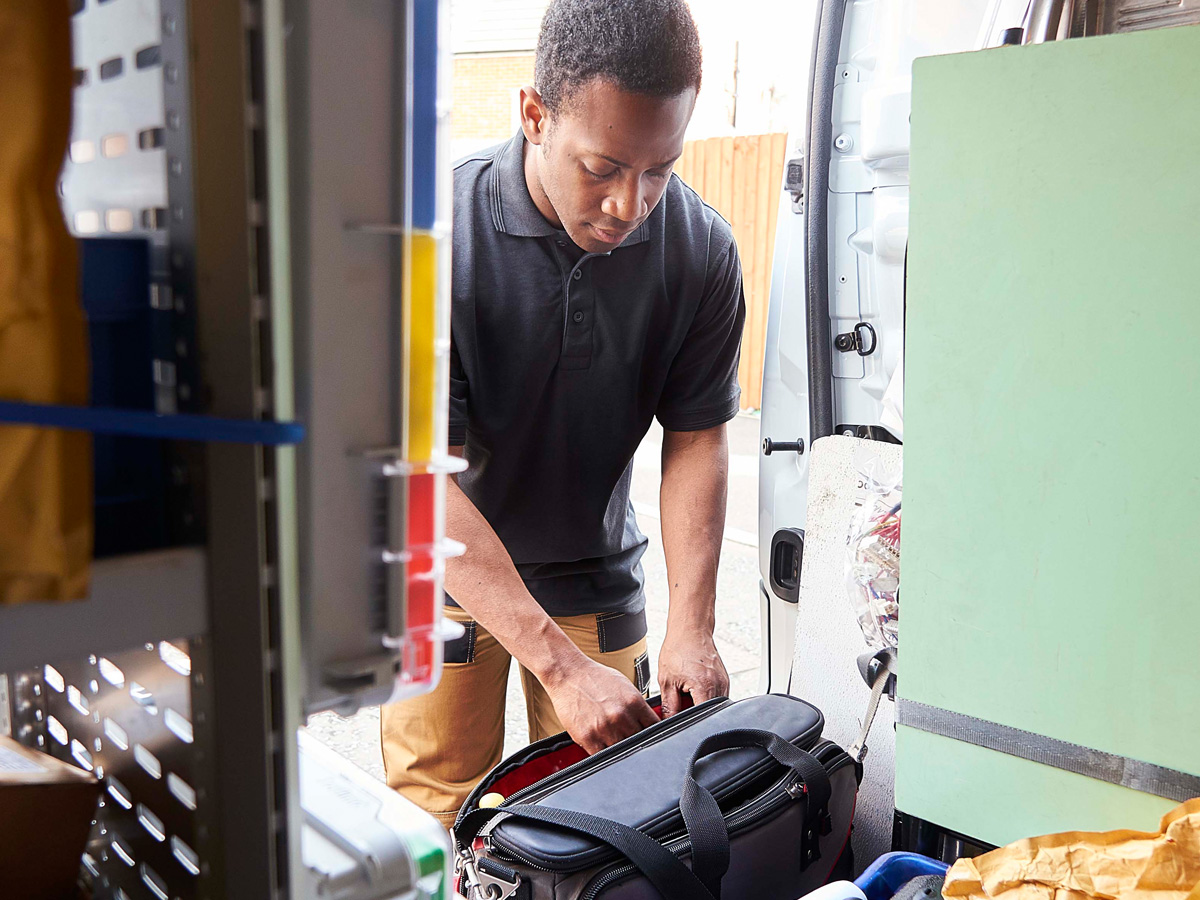 Field Service Worker taking tool from a bag within his van