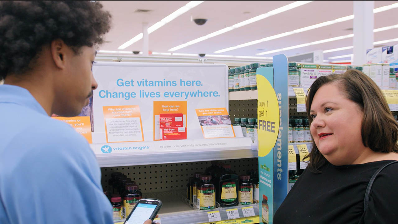 A Walgreens associate helps a customer