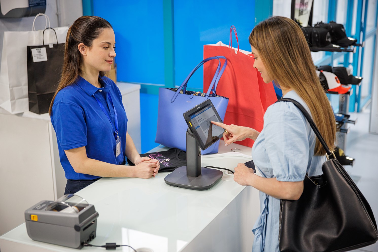 A shopper uses a Zebra tablet set up as part of the Workstation Connect solution to purchase an item