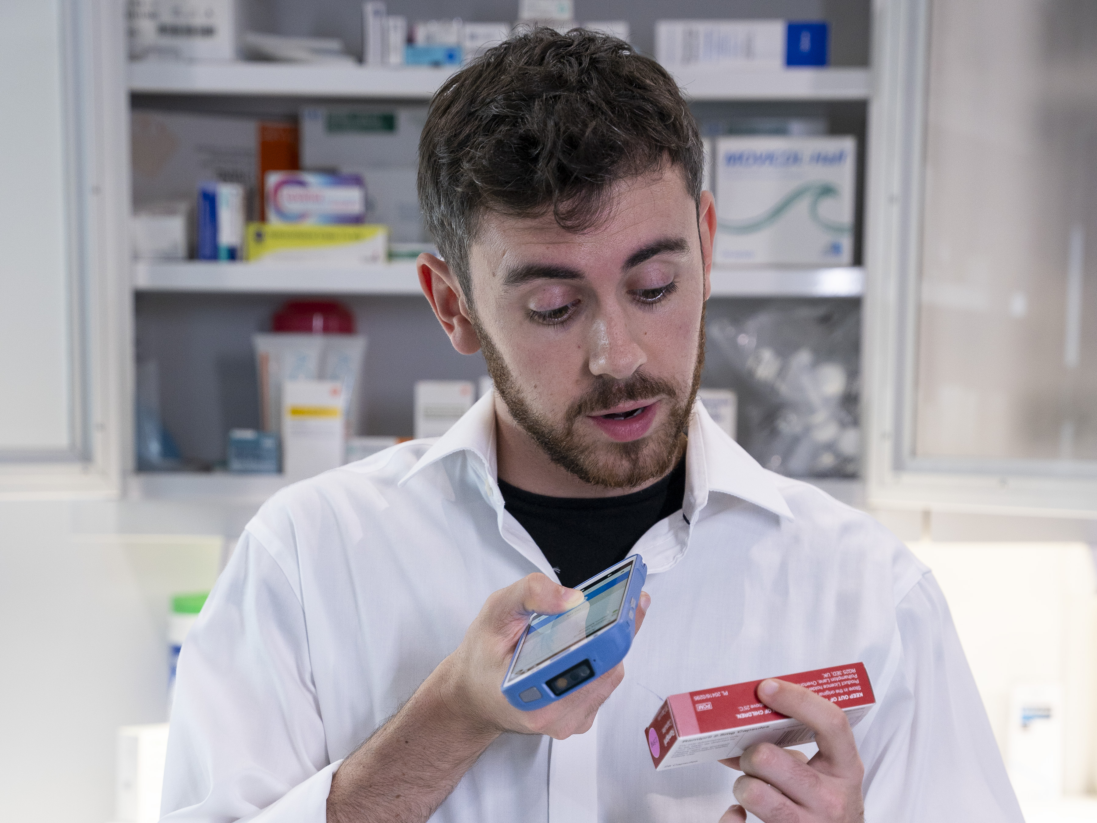 A pharmacist uses their Zebra HC50 mobile device to verify a prescription