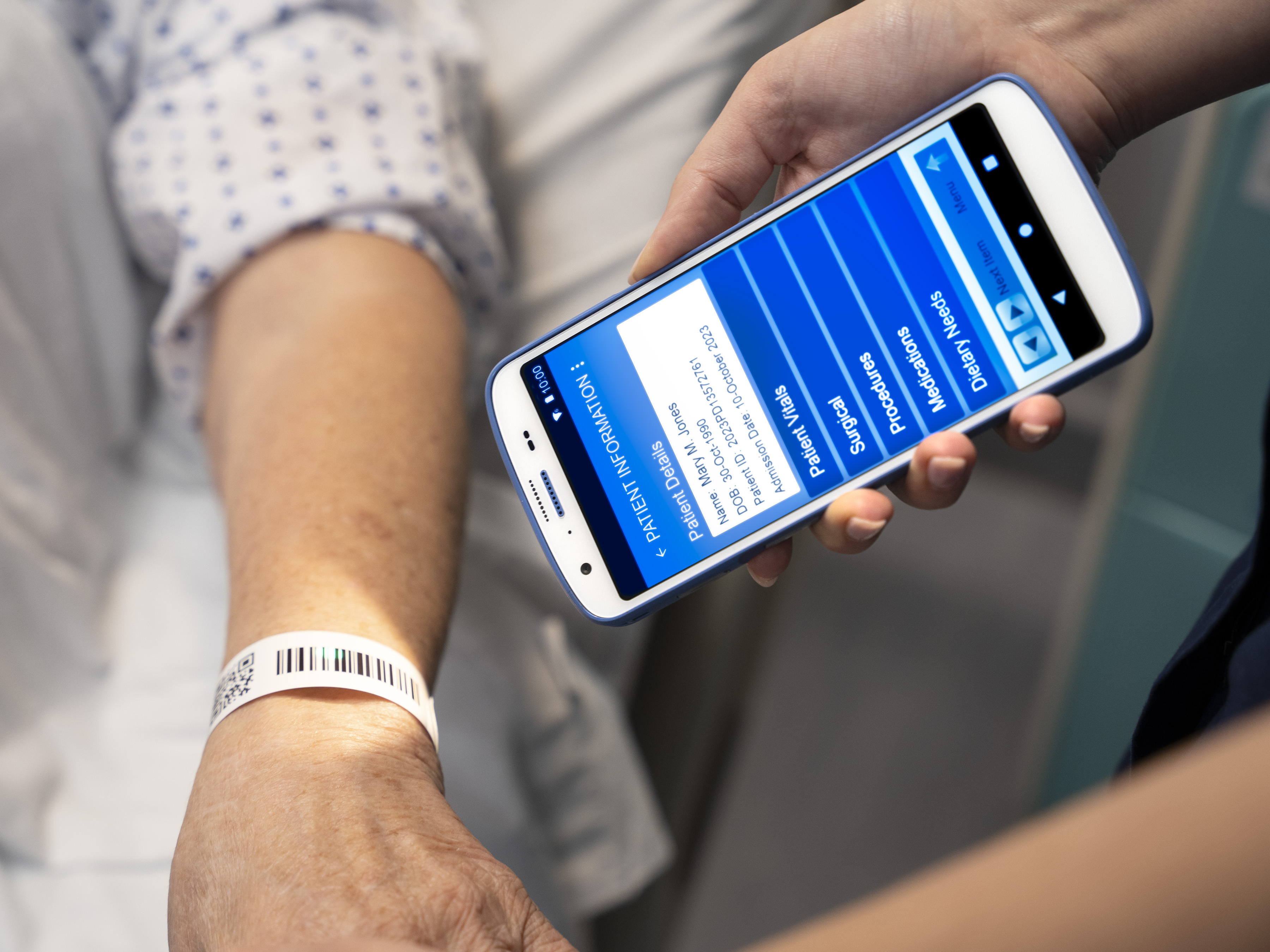 A nurse uses a Zebra device to scan the barcode on a patient's wristband