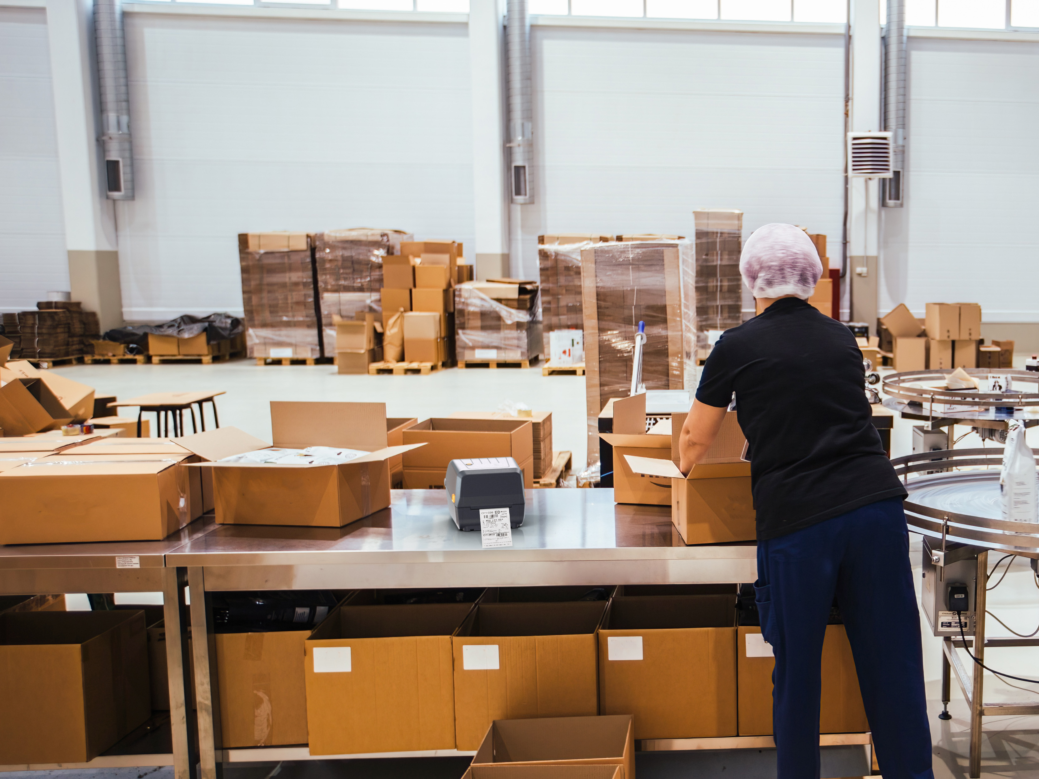 A warehouse worker packs boxes