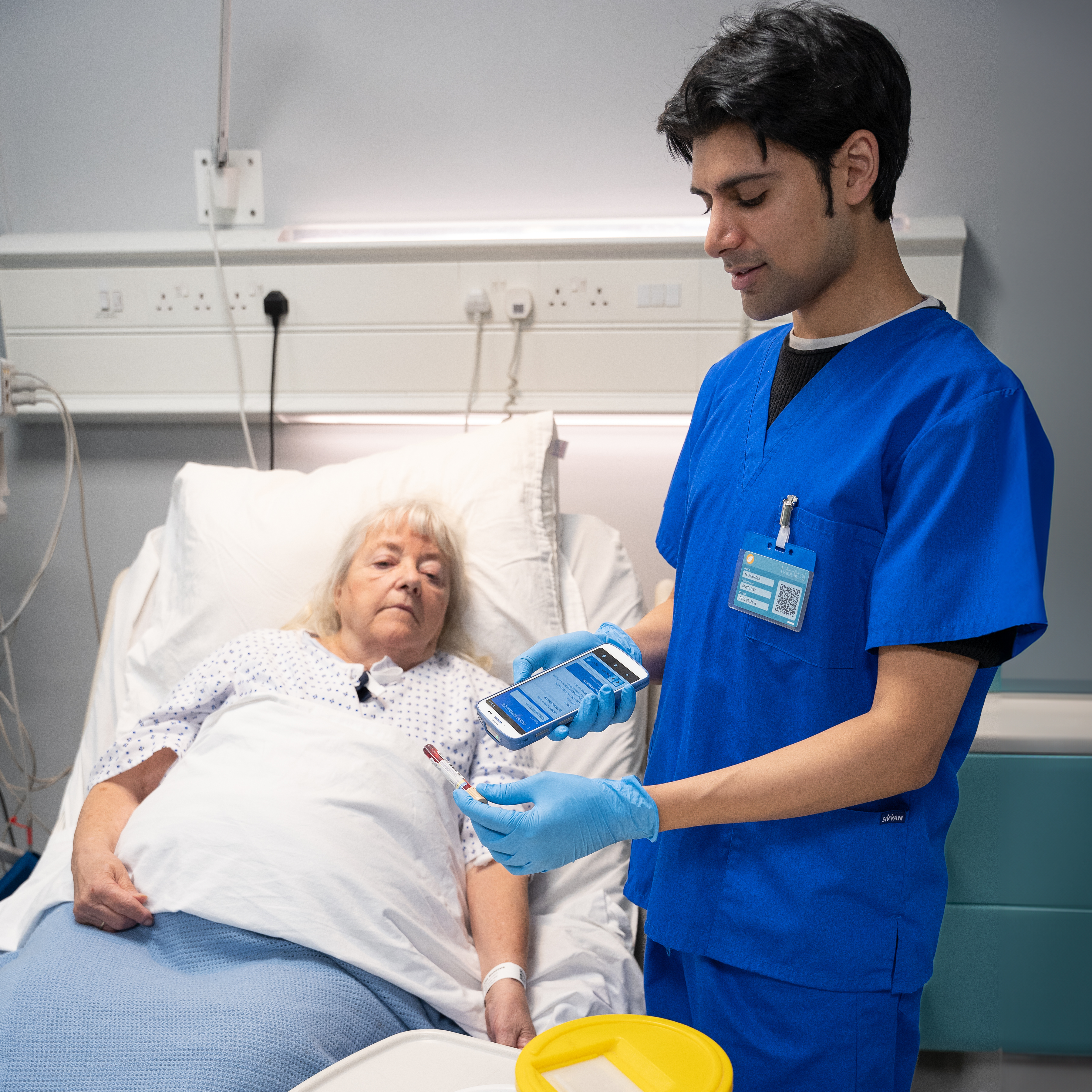 healthcare-photography-website-hc20-patient-bedside-scanning-blood-vial-portrait-mode-row-16x9-3600x3600